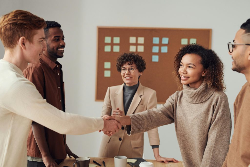 pexels-photo-3184649-3184649 A diverse group of colleagues shaking hands during a productive office meeting.