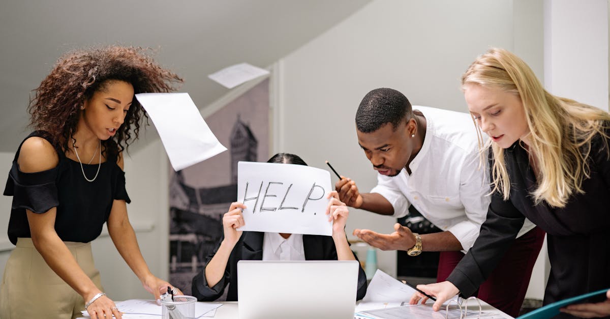 Team of stressed colleagues in an office dealing with paperwork chaos, asking for help.